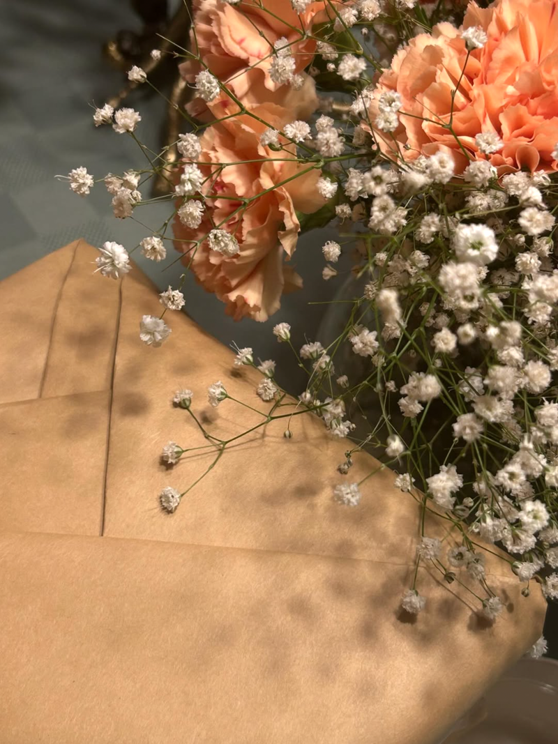 A close up of a wrapped mystery book and flowers